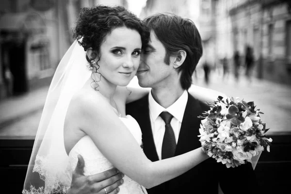 Black and white picture of an elegant bride sitting on groom's k — Stock Photo, Image