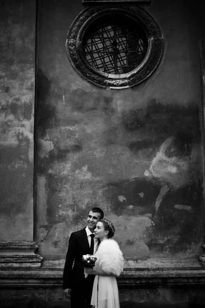 Preto e branco imagem de elegante casal posando sob o velho w — Fotografia de Stock