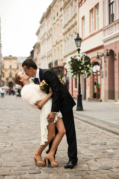 Bräutigam küsst leidenschaftlich eine Braut im kurzen Kleid — Stockfoto