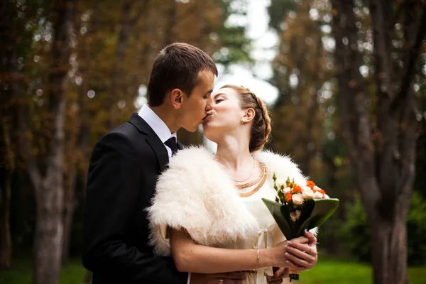 Groom embrasse une mariée élégante en châle de fourrure par derrière — Photo