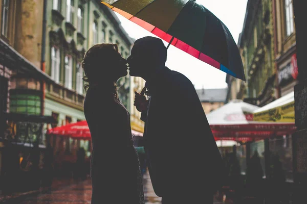 Silhouette di una coppia che si bacia sotto un ombrello — Foto Stock