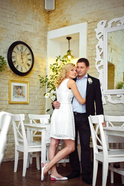 Sposa in abito corto bianco si appoggia alla spalla dello sposo mentre in piedi — Foto Stock