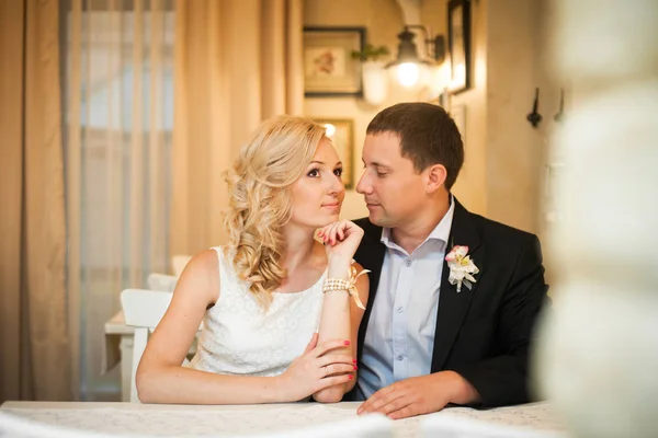 Vőlegény egy átgondolt menyasszony csodálja az asztalnál ülve — Stock Fotó