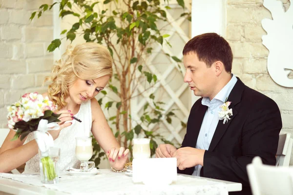 Groom regarde une mariée pendant qu'elle met du sucre dans un verre avec du coff — Photo