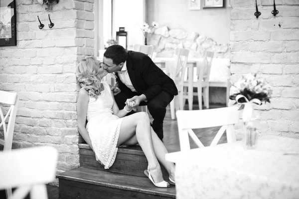 Bräutigam lehnt sich an eine Braut, während sie auf dem Boden im leeren sitzt — Stockfoto