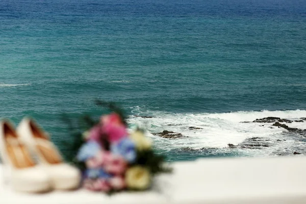 Deniz sıçramalarına kayaların arkasında Düğün Ayakkabı ile blacony üzerinden