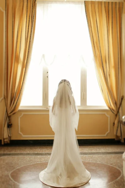 Смотри сзади на прекрасную невесту, спрятанную под вуалем, пока она — стоковое фото