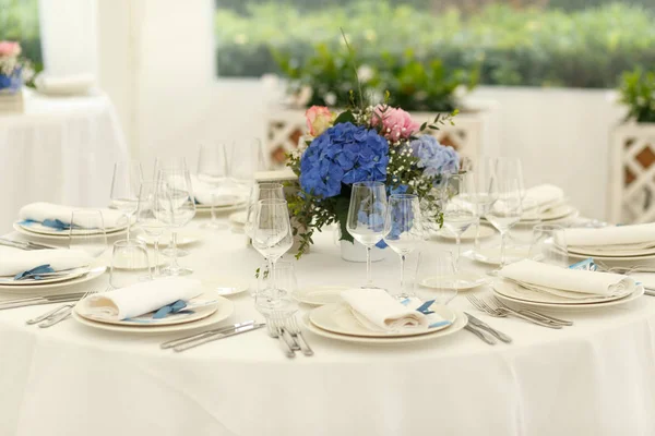 Weiße Servietten und blaue Bänder liegen über dem festlichen Geschirr — Stockfoto
