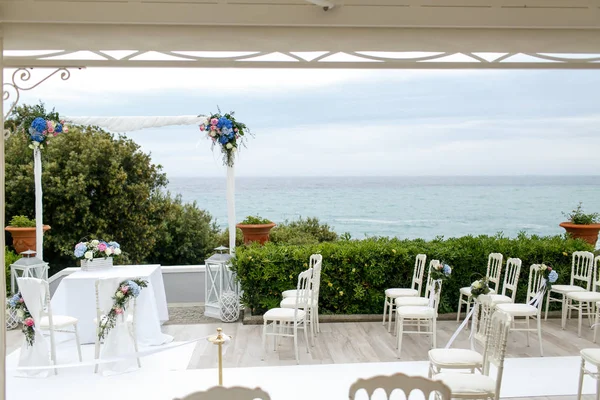 Sillas a la espera de un puesto de ceremonia de boda en el porche sobre th — Foto de Stock