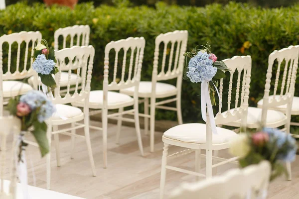 Wazig beeld van blauwe hortensia's zetten witte stoelen — Stockfoto