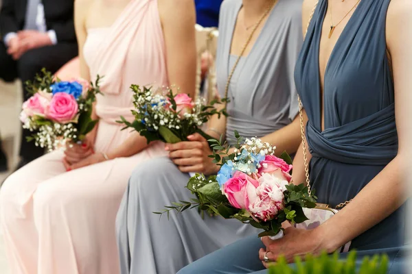 Dama de honra em azul, cinza e rosa vestidos sentar-se no raio — Fotografia de Stock