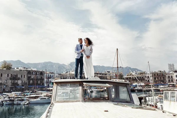 Homem de terno azul fica com uma mulher bonita no barco branco — Fotografia de Stock