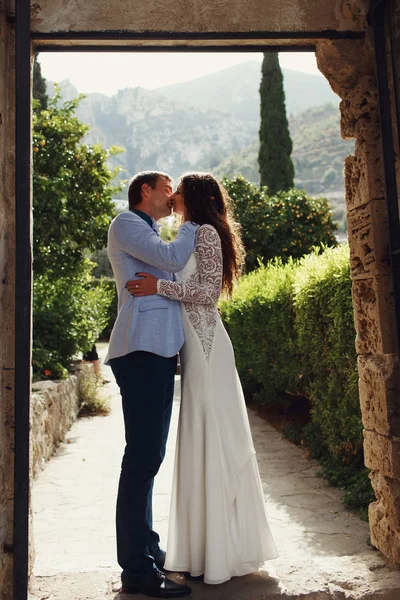 Sposo baci sposa tenera mentre si trovano all'ingresso del th — Foto Stock