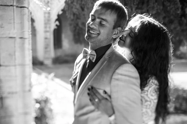 Preto e branco imagem de um noivo sorrindo enquanto a noiva se inclina para — Fotografia de Stock