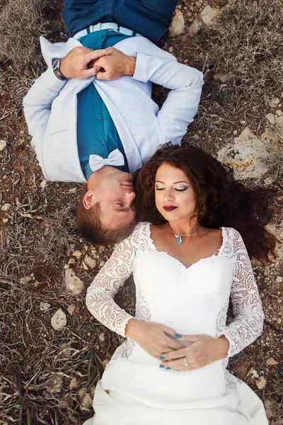 Os recém-casados deitam-se no chão cabeça a cabeça — Fotografia de Stock