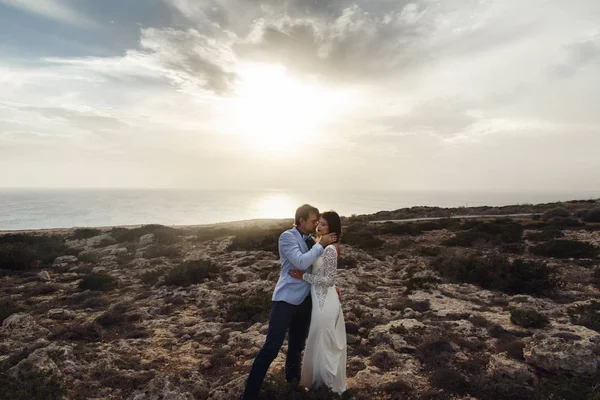 Soirée soleil freine le ciel sur le couple de mariage étreignant sur th — Photo