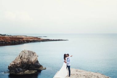 Masmavi deniz kayaya sarılma bir evlilik çift etrafında yayılır