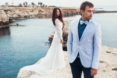 Güzel esmer uzun gelinlik bl bir erkeğin arkasında duruyor