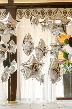 Gümüş baloons asmak kahverengi tavan altında