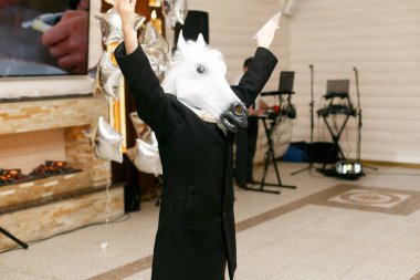 Beyaz at maskeli adam Restoran ortasında duruyor 