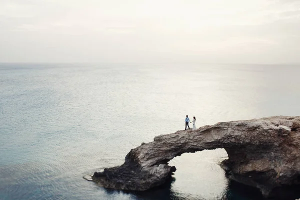 Çift düğün doğal taş köprü üzerinde yürüyor — Stok fotoğraf