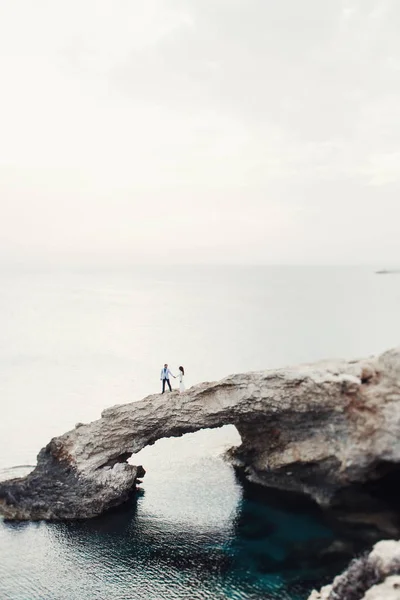 Yeni evli olduğun yerde kayanın altında mavi deniz parıldıyor — Stok fotoğraf