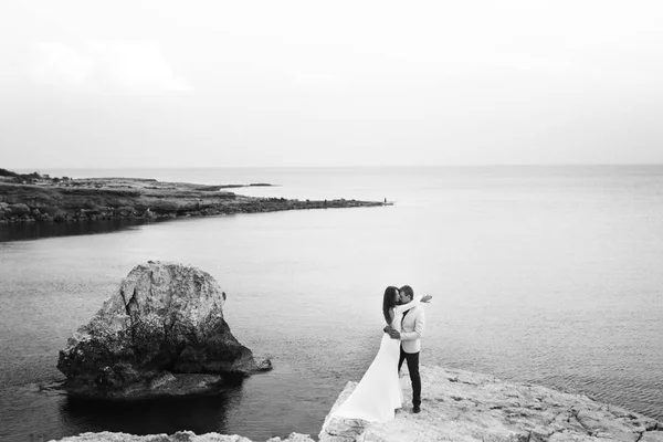 Photo en noir et blanc d'une femme embrassant un homme sur le rocher — Photo