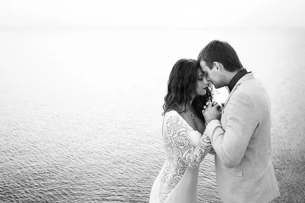 Man holds woman's hands delicately standing by the sea — Stock Photo, Image