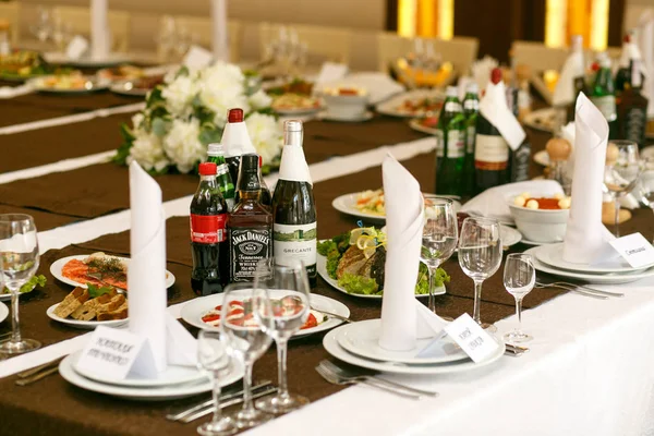 Drankjes staan tussen witte platen op bruin tafellaken — Stockfoto