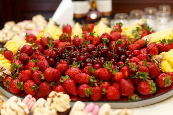 Red cherries lie in the middle of plate served with strawberries — Stock Photo, Image