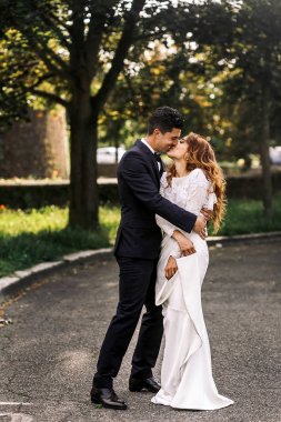 Damat onu sıkıca sarılarak iken gelin elbisesini tutar