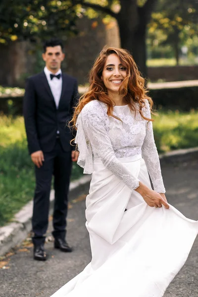 Linda noiva encaracolado gira seu vestido eleganr posando no fron — Fotografia de Stock