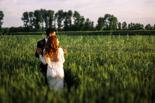 Van achteren kijk op een prachtige bruid leunend naar een bruidegom terwijl wa — Stockfoto