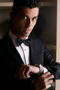 Bronz tenli yakışıklı adam bir kol saatini ayarlar.