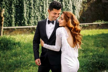 Geri bir smilin eğilir iken uzun altın kapak gelinin bukleler