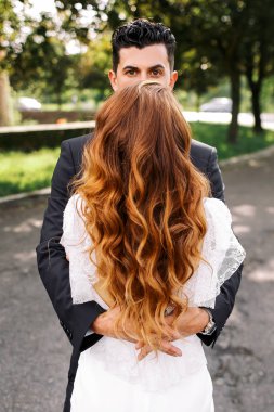 Onun altın bukleler askıda iken esmer adam kadının kafasına görünüyor