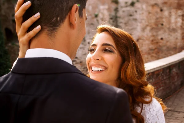 Guarda dalle spalle dello sposo il sorriso di una splendida sposa mentre sh — Foto Stock