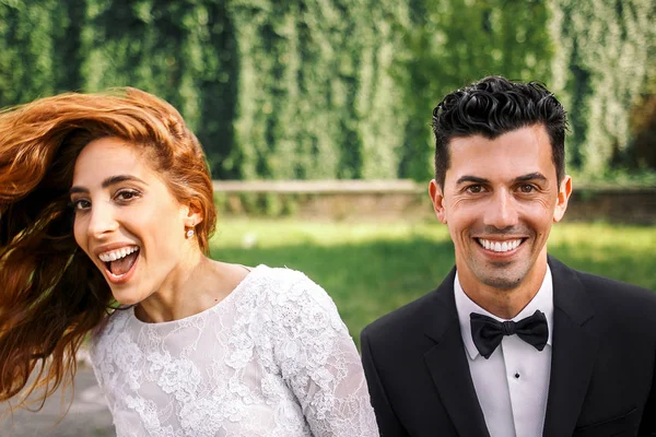 Beau brunette marié se tient devant s rire mariée tourbillonnant — Photo