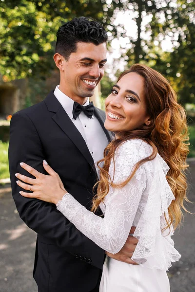 Morena novio con piel de bronce abraza novia con el pelo impresionante — Foto de Stock