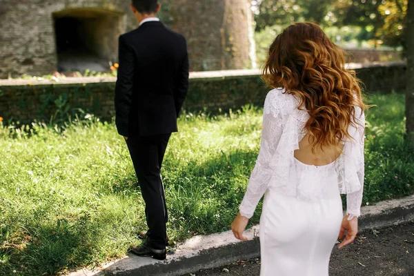 Il vento soffia i capelli della sposa sulle spalle mentre cammina verso un gr — Foto Stock