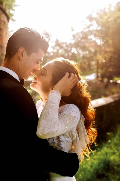 Летнее солнце светит над потрясающей свадебной парой, улыбающейся перед — стоковое фото