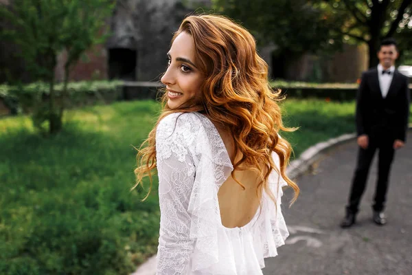 Woman with big eyes and gorgeous curls looks over her shoulder c