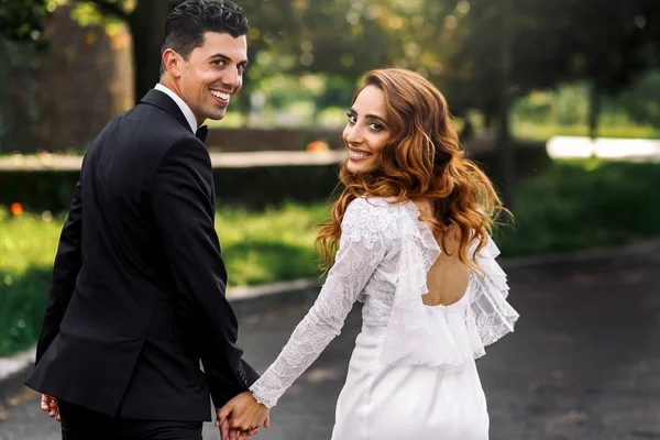 Sun shines over the newlyweds with sparkling smiles — Stock Photo, Image