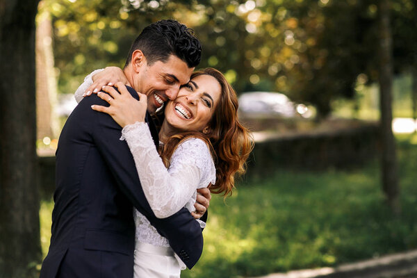 Mariée et marié s'embrassent étroitement tout en riant dans le pair — Photo