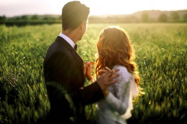 Güneş üzerinde yeni evliler hoding onların elleri birlikte watchi parlıyor.