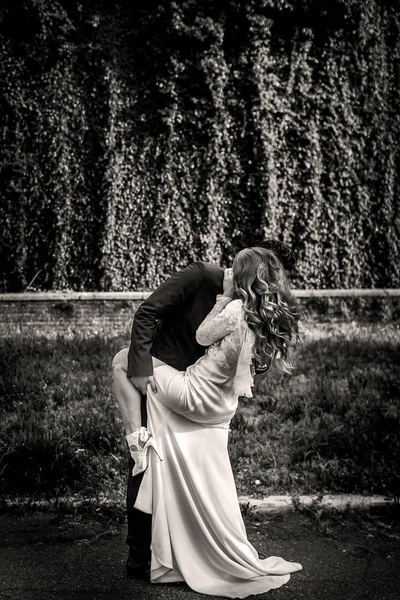 L'uomo tiene la gamba della donna mentre la piega nel giardino — Foto Stock