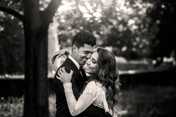 Foto en blanco y negro de la hermosa pareja de boda abrazándose en th — Foto de Stock