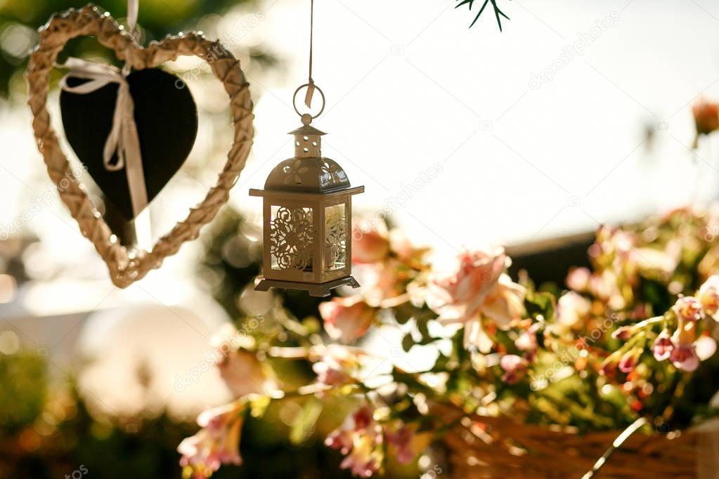 White lantern hangs over the basket of roses