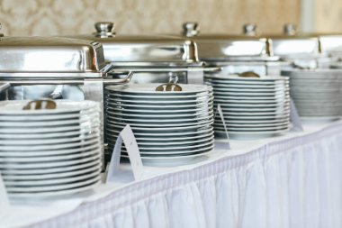 Beyaz tabak yığınları üzerinde beyaz büfe standı