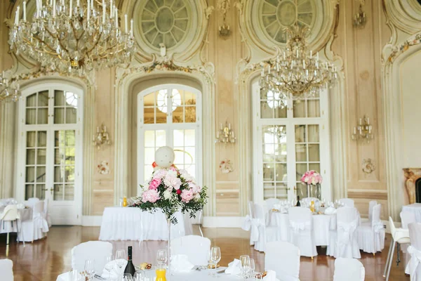 Magnificent crystal chandelier hang over the white dinner tables — Stock Photo, Image